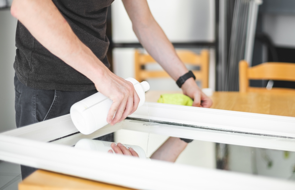 Professional safely removing a large wall mirror during a residential mirror removal service