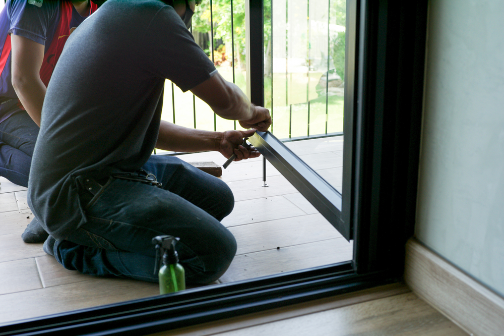 Mirror repair experts inspecting and repairing a cracked wall mirror