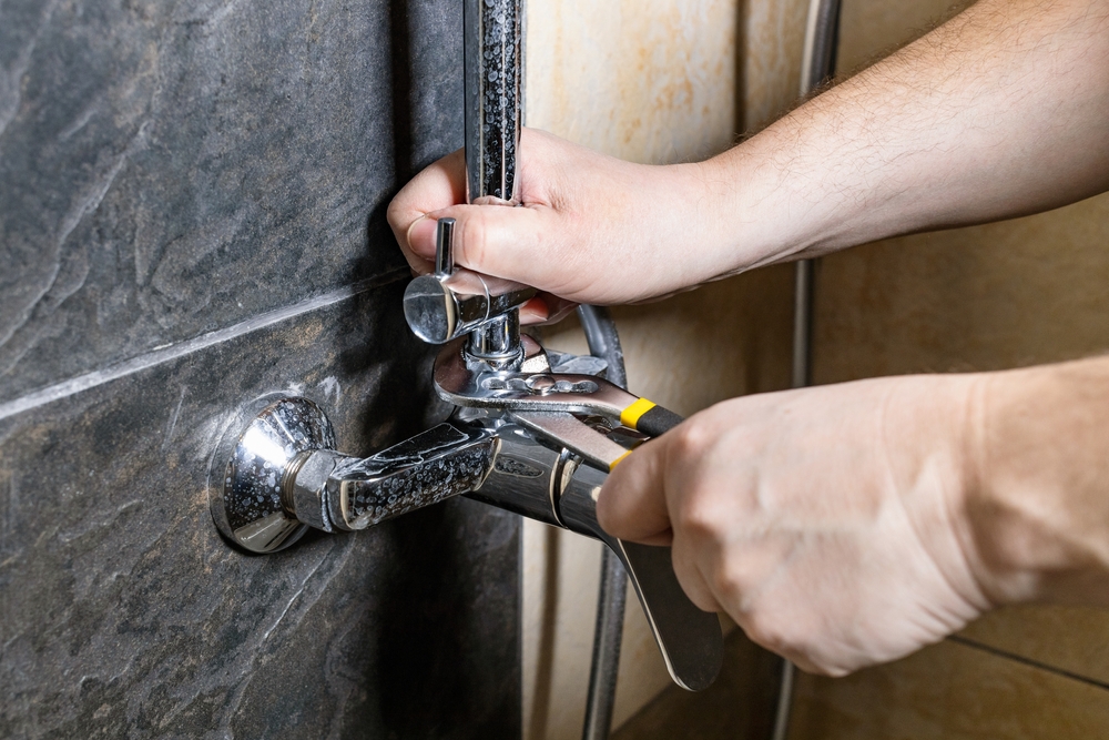 Plumber inspecting common shower problems in a residential bathroom