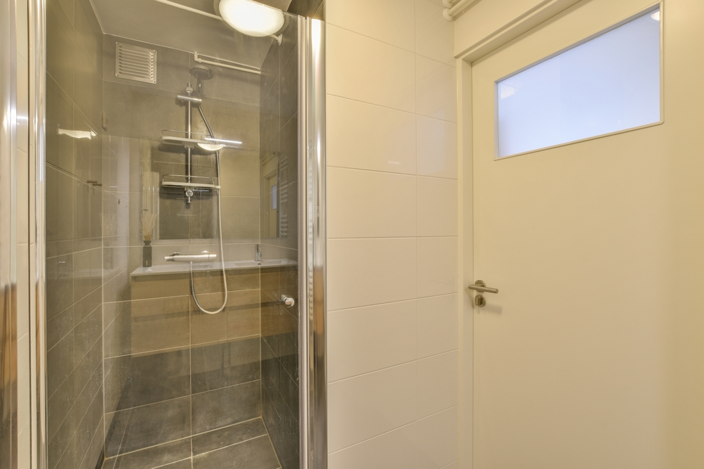 Professional installer completing frameless shower glass installation in a Palm Springs bathroom