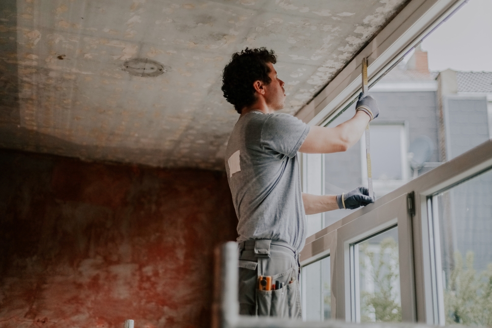 Homeowner comparing window repair vs window replacement options for a residential home