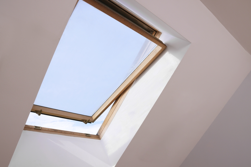 Professional inspecting a skylight for signs that it needs replacement