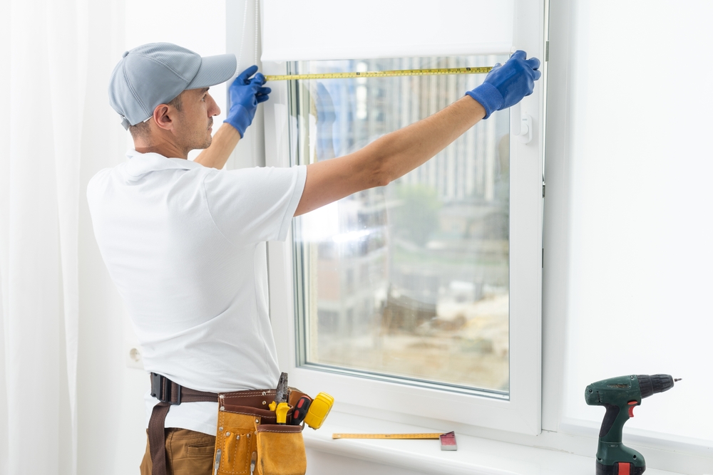 Window repair technician fixing common window glass problems in a residential home